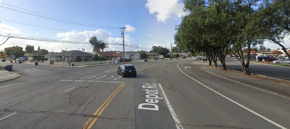 Google street view image of a very wide Depot Rd at Adrian Ave in Hayward, with five travel lanes but only a single car in the image