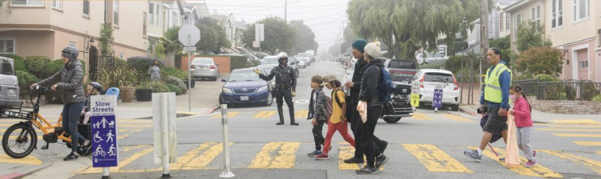 Photo of a slow street activation with people crossing a crosswalk on foot