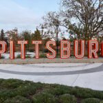 Large illuminated "Pittsburg" sign on a pedestal